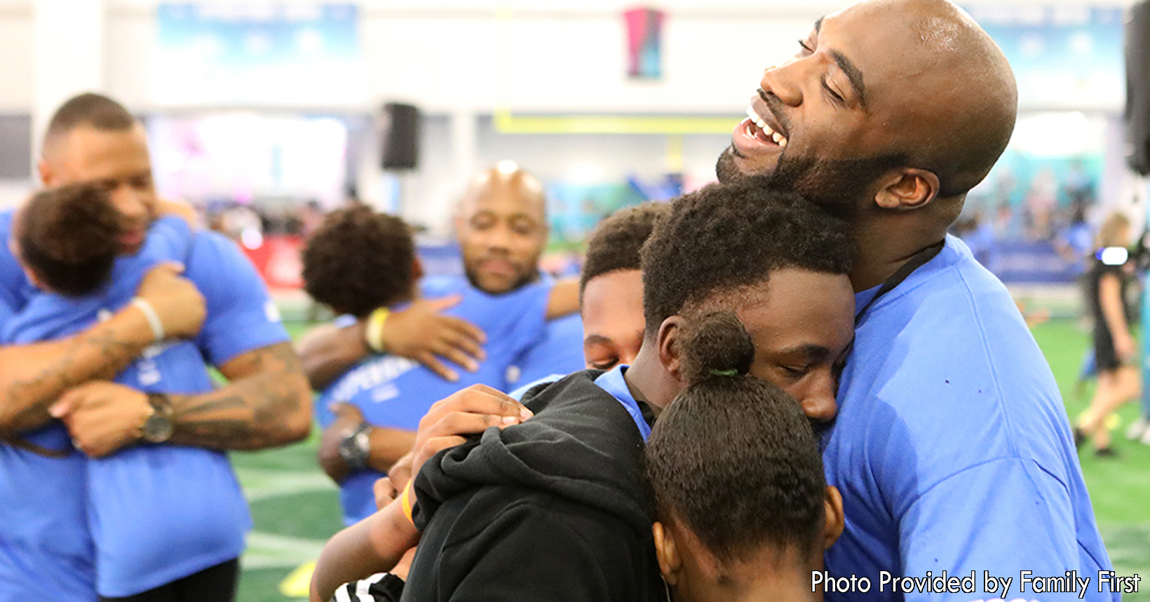 These young fathers are participating with their children in one of the All Pro Dads events held by Family First. Each one of the dads are embracing their children with great big hugs. Strengthening their bond will allow them to create great memories.