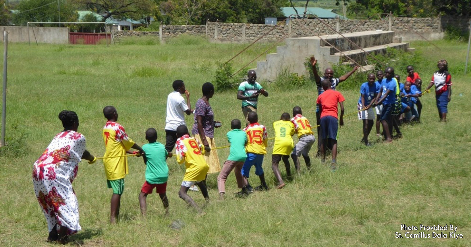 Children play games in a grassland area of the campus.