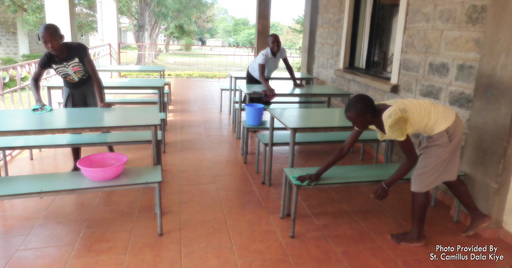 Girls clean the tables near their house as part of their chores.