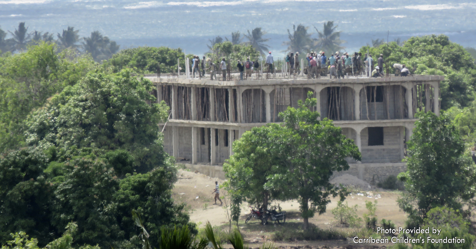 In August 2019, when it was time to put the roof of the second floor on the building, over 100 people showed up to work and celebrate this big blessing for the island. The only payment they wanted was a meal of rice and beans at the end of the day. People came to mix mortar, transport water to the worksite bucketload by bucketload, prepare the meal for the workers, hoist cement up to the roof, lay cement on the roof and many other tasks. This photo shows some of the workers on top of the building as they completed laying down the thick layer of cement.
