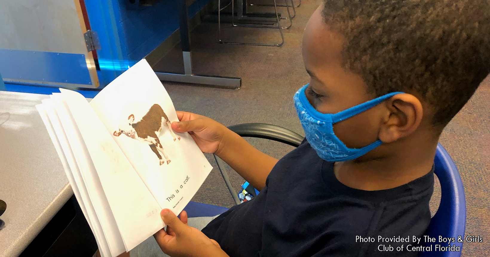 Khi'el participating in the tutoring program reading a book his teacher asked for us to help him with.