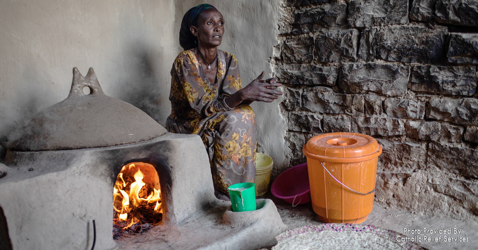 Febedu Mehari is cooking injera in her home. With the support from the CRS, she doesn’t need to sell her milk, goats, and hens to provide food for her family.