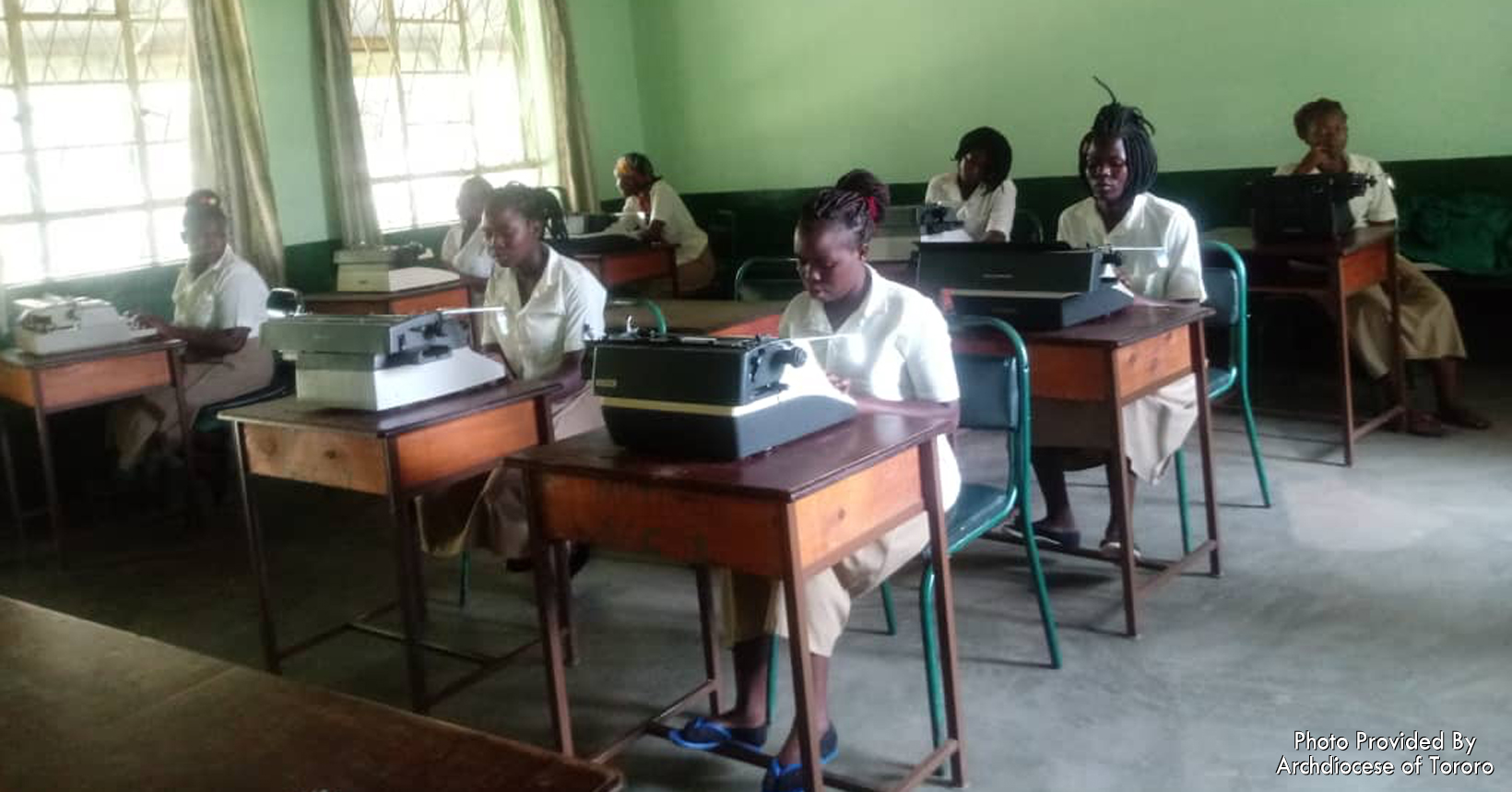 These young girls are secretarial students and are practicing typing on their manual typewriters.