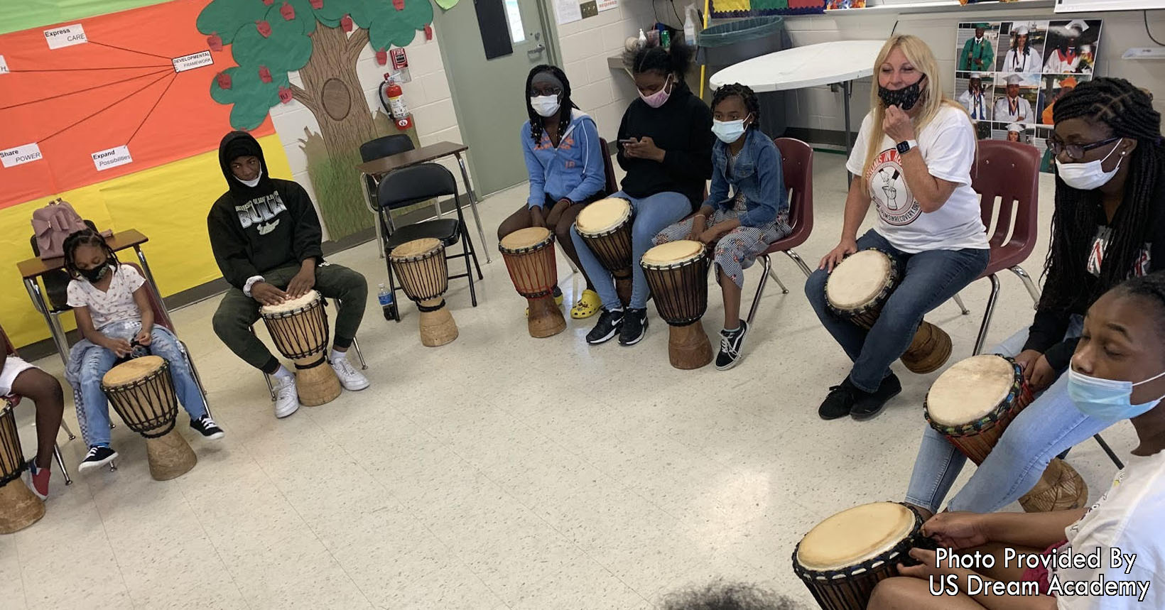 A group of students participate in a drum circle.
